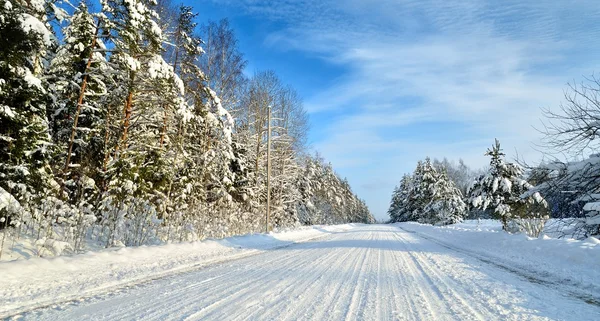 Route dans une campagne ensoleillée en journée d'hiver. Paysage hivernal couvert de neige classique — Photo