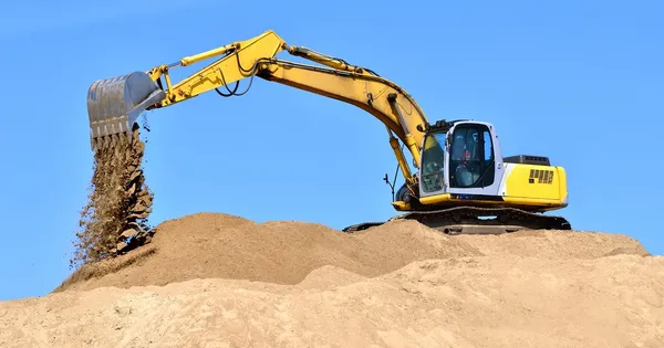 Yeni sarı ekskavatör kum tepeleri üzerinde çalışma