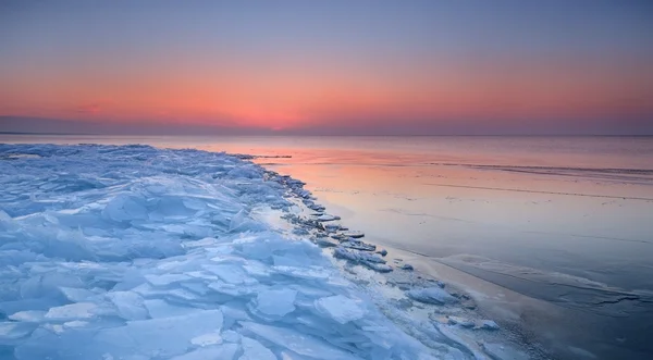 Farbenfroher Sonnenuntergang an der schneebedeckten Ostseeküste — Stockfoto