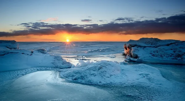 Pôr-do-sol colorido na costa nevada do mar Báltico — Fotografia de Stock