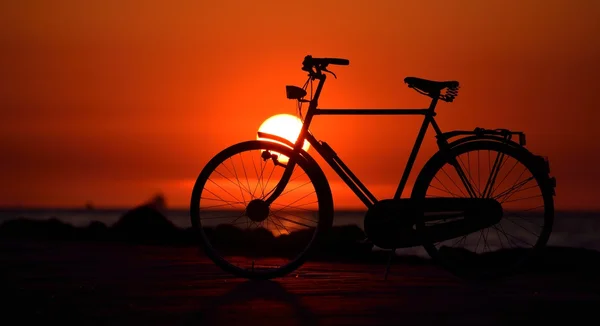 Altes holländisches Retro-Fahrrad am Strand gegen den roten Sonnenuntergang — Stockfoto