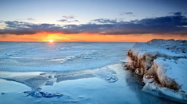 Colorful sunset at the snowy Baltic sea shore Royalty Free Stock Images