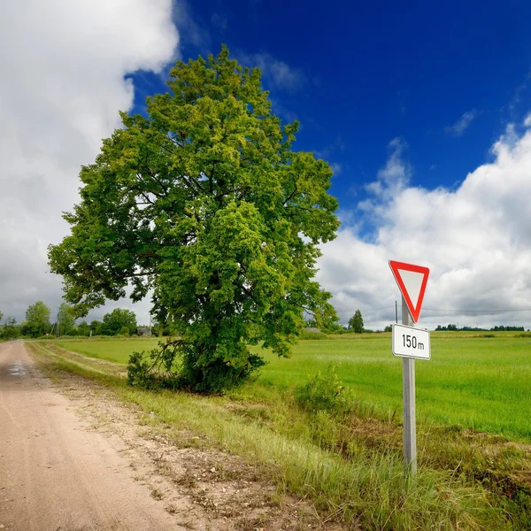 Зеленое поле и дорожный знак — стоковое фото