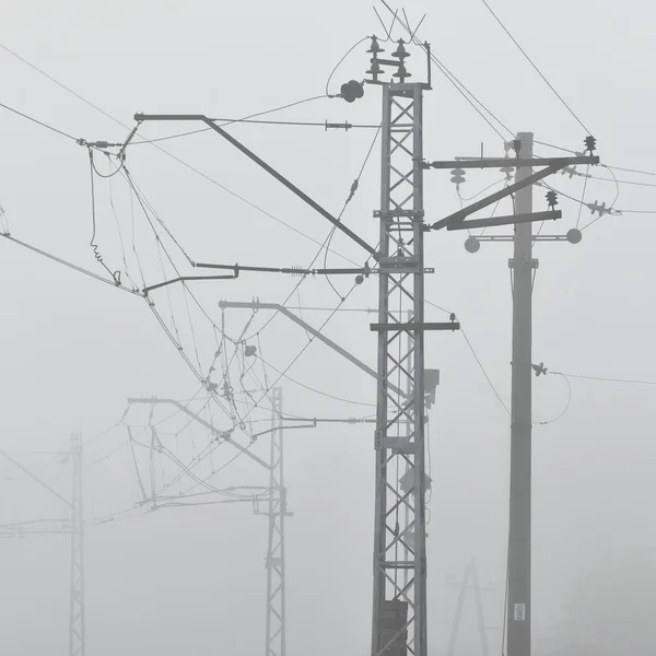Railroad cable power lines in strong fog — Stock Photo, Image