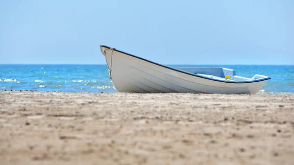 White rowboat on a sea beach — Stock Photo, Image