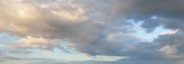 Açık mavi gökyüzü. Pembe ve altın rengi sirrus ve kümülüs bulutları fırtına üstüne, yumuşak güneş ışığı. Dramatik gün batımı bulutları. Meteoroloji, cennet, barış, grafik kaynakları, pitoresk panoramik manzara