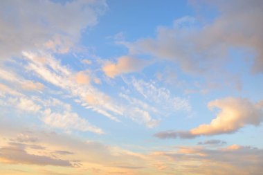 Açık mavi gökyüzü. Pembe ve altın rengi sirrus ve kümülüs bulutları fırtına üstüne, yumuşak güneş ışığı. Dramatik gün batımı bulutları. Meteoroloji, cennet, barış, grafik kaynakları, pitoresk panoramik manzara