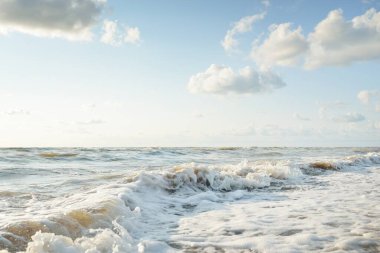Fırtınadan sonra Baltık kıyıları. Gün batımı, yumuşak altın güneş ışığı. Su yüzeyi dokusu, çarpan dalgalar ve sıçramalar. Resimli panoramik manzara. Idyllic deniz manzarası. Doğa, çevre, ekoloji temaları