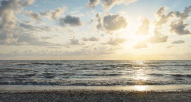 Fırtınadan sonra Baltık kıyıları (kum tepeleri, plaj). Gün batımı, yumuşak altın güneş ışığı, parlayan bulutlar. Resimli panoramik manzara. Doğa, çevre, ekoloji, eko-turizm, yürüyüş, keşif kavramları