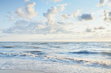 Fırtınadan sonra Baltık kıyıları. Gün batımı, yumuşak altın güneş ışığı, parlayan bulutlar. Resimli panoramik manzara. Doğa, çevre, ekoloji, eko-turizm, yürüyüş, keşif kavramları