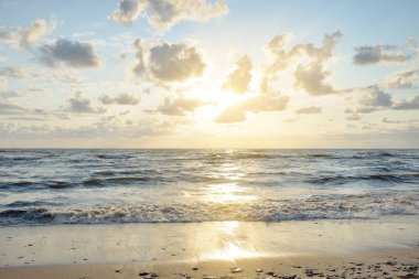 Fırtınadan sonra Baltık kıyıları. Gün batımı, yumuşak altın güneş ışığı, parlayan bulutlar. Resimli panoramik manzara. Doğa, çevre, ekoloji, eko-turizm, yürüyüş, keşif kavramları