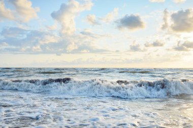 Fırtınadan sonra Baltık kıyıları. Gün batımı, yumuşak altın güneş ışığı, parlayan bulutlar. Resimli panoramik manzara. Doğa, çevre, ekoloji, eko-turizm, yürüyüş, keşif kavramları