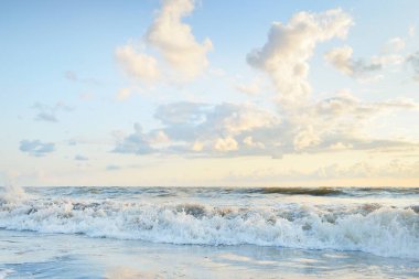 Fırtınadan sonra Baltık kıyıları. Gün batımı, yumuşak altın güneş ışığı, parlayan bulutlar. Resimli panoramik manzara. Doğa, çevre, ekoloji, eko-turizm, yürüyüş, keşif kavramları