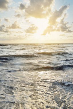 Fırtınadan sonra Baltık kıyıları. Gün batımı, yumuşak altın güneş ışığı, parlayan bulutlar. Resimli panoramik manzara. Doğa, çevre, ekoloji, eko-turizm, yürüyüş, keşif kavramları