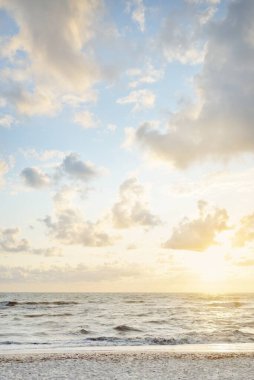 Fırtınadan sonra Baltık kıyıları (kum tepeleri, plaj). Gün batımı, yumuşak altın güneş ışığı, parlayan bulutlar. Resimli panoramik manzara. Doğa, çevre, ekoloji, eko-turizm, yürüyüş, keşif kavramları