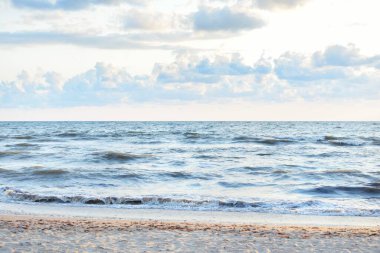 Fırtınadan sonra Baltık kıyıları (kum tepeleri, plaj). Gün batımı, yumuşak altın güneş ışığı, parlayan bulutlar. Resimli panoramik manzara. Doğa, çevre, ekoloji, eko-turizm, yürüyüş, keşif kavramları