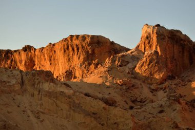 Gün batımında kırmızı kumtaşı kanyonunun panoramik manzarası. Açık mavi gökyüzü. Atmosferik manzara. Seyahat noktaları, dönüm noktaları, doğa, çevre, ekoloji, eko-turizm, yürüyüş, keşif