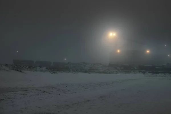 ライトアップされた雪に覆われたバルト海の海岸 背後のポートターミナル 黒と白の冬の風景 生態系 環境被害 燃料と発電の概念 — ストック写真