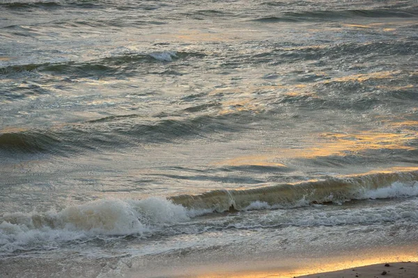 风暴过后的波罗的海海岸 夕阳西下 柔和的金色阳光 水面纹理 波纹破碎 浪花飞溅 风景如画的全景 生态概念 — 图库照片