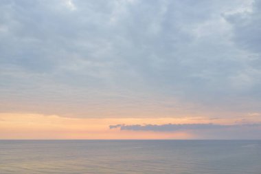Gün batımında Baltık Denizi 'nin manzaralı panoramik manzarası. Fırtınadan sonra dramatik bir gökyüzü, parlayan bulutlar, altın güneş ışığı. Saf doğa, çevre, eko-turizm, kararsız hava, iklim değişikliği
