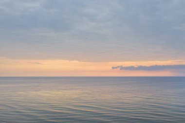 Gün batımında Baltık Denizi 'nin manzaralı panoramik manzarası. Fırtınadan sonra dramatik bir gökyüzü, parlayan bulutlar, altın güneş ışığı. Saf doğa, çevre, eko-turizm, kararsız hava, iklim değişikliği