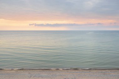 Gün batımında Baltık Denizi 'nin manzaralı panoramik manzarası. Fırtınadan sonra dramatik bir gökyüzü, parlayan bulutlar, altın güneş ışığı. Saf doğa, çevre, eko-turizm, kararsız hava, iklim değişikliği