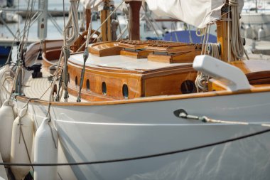 Yeni bir yat limanındaki iskeleye demirlenmiş pahalı bir retro yelkenli (ketch). Tahta meşe güvertesi, zarif detaylar. Ulaşım, denizcilik gemisi, tatiller, turizm, seyahat, yat yarışı, dinlenme