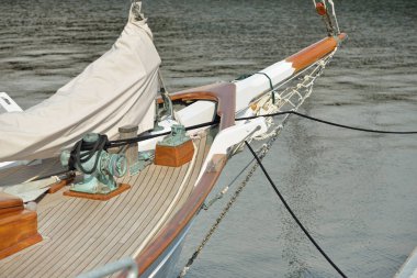 Yeni bir yat limanındaki iskeleye demirlenmiş pahalı bir retro yelkenli (ketch). Tahta meşe güvertesi, zarif detaylar. Ulaşım, denizcilik gemisi, tatiller, turizm, seyahat, yat yarışı, dinlenme