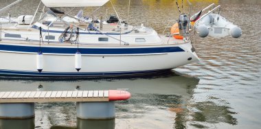 Yeni bir yat limanında limana demirlemiş beyaz yelkenli. Deniz aracı, ulaşım, spor, yelkenli yarışı, tatiller, eğlence, eğlence, eğlence, turizm, yat kulübü, servis