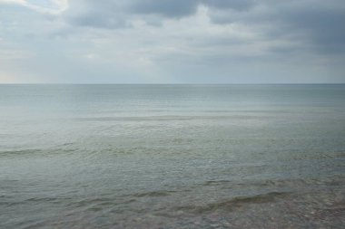Fırtınadan sonra Baltık kıyıları (kum tepeleri, plaj). Gün batımı, parlayan kara bulutlar. Resimli panoramik manzara. Doğa, çevre, ekoloji, eko-turizm, yürüyüş, keşif kavramları