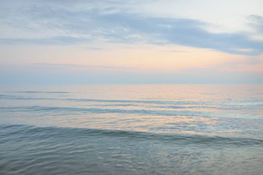 Yağmurdan sonra Baltık Denizi. Dramatik günbatımı gökyüzü, parlayan pembe ve altın fırtına bulutları. Resimli panoramik manzara. Doğa, çevre, değişken hava, kasırga