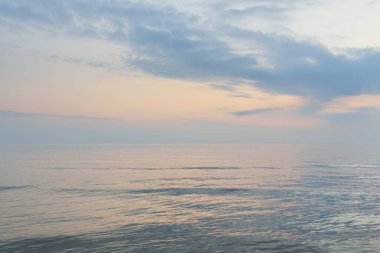 Yağmurdan sonra Baltık Denizi. Dramatik günbatımı gökyüzü, parlayan pembe ve altın fırtına bulutları. Resimli panoramik manzara. Doğa, çevre, değişken hava, kasırga