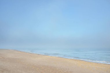 Güneşin doğuşunda sisli bir havada Baltık Denizi manzarası. Kumsal, kum tepeleri. Yumuşak güneş ışığı. Idyllic yaz deniz manzarası. Doğa, çevre, tatiller, eko-turizm, yürüyüş ve keşif kavramları