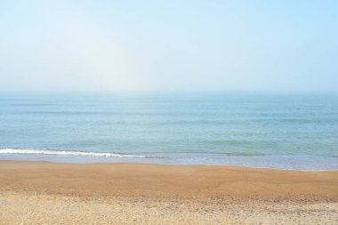Güneşin doğuşunda sisli bir havada Baltık Denizi manzarası. Kumsal, kum tepeleri. Yumuşak güneş ışığı. Idyllic yaz deniz manzarası. Doğa, çevre, tatiller, eko-turizm, yürüyüş ve keşif kavramları
