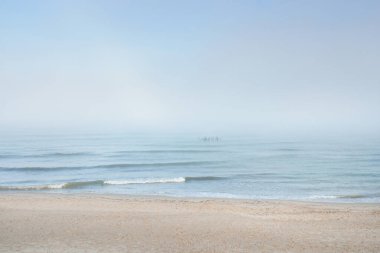 Güneşin doğuşunda sisli bir havada Baltık Denizi manzarası. Kumsal, kum tepeleri. Yumuşak güneş ışığı. Idyllic yaz deniz manzarası. Doğa, çevre, tatiller, eko-turizm, yürüyüş ve keşif kavramları