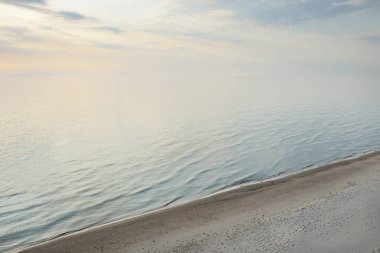 Fırtınadan sonra Baltık kıyılarından panoramik hava manzarası. Temiz gün batımı gökyüzü, yansımalar, durgun su yüzeyi dokusu. Doğa, çevre. Idyllic rüya gibi deniz manzarası