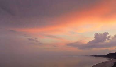 Fırtınadan sonra Baltık kıyılarından panoramik hava manzarası. Kum tepeleri. Dramatik gökyüzü, parlak pembe ve altın bulutlar. Doğa, çevre, eko-turizm, yaz tatilleri. Idyllic rüya gibi deniz manzarası
