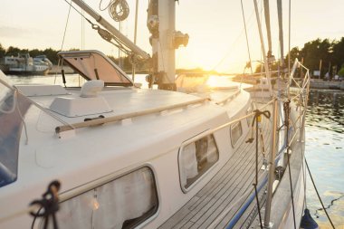 Günbatımında yat limanında bir rıhtıma demirlenmiş ahşap meşe güverteli eski klasik yelkenli. Tatiller, ulaşım, spor, eğlence, turizm, seyahat, liman