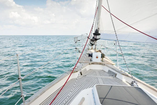 Herreshoff designed old classic yacht sailing in an open sea. Wooden teak deck. View to the mast and sails. Ketch sailboat. North American boat building traditions. Cruise, vacations, regatta, sport