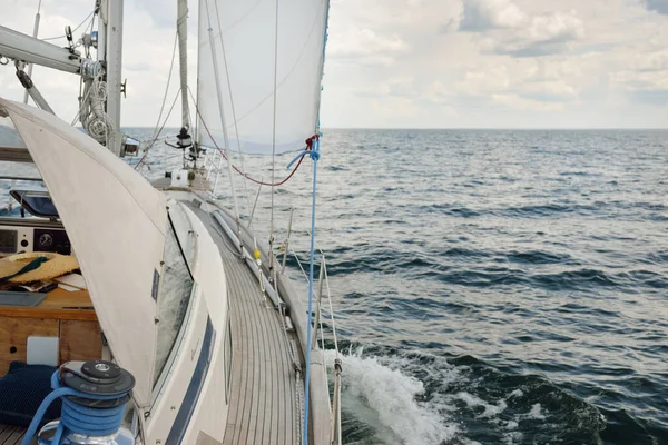 Herreshoff designed old classic yacht sailing in an open sea. Wooden teak deck. View to the mast and sails. Ketch sailboat. North American boat building traditions. Cruise, vacations, regatta, sport