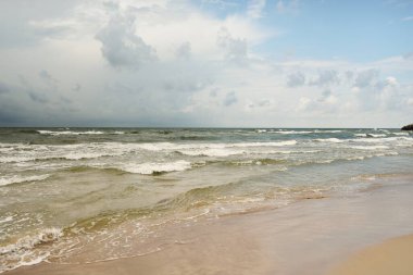Fırtınadan sonra Baltık kıyıları (kum tepeleri, plaj). Dramatik gökyüzü, parlayan bulutlar. Resimli panoramik manzara. Doğa, çevre, ekoloji, eko-turizm, yürüyüş, keşif kavramları