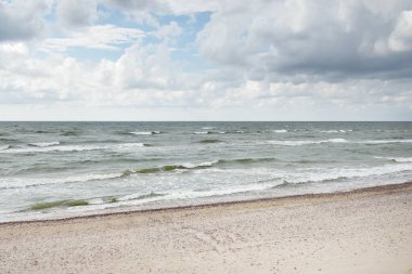 Fırtınadan sonra Baltık kıyıları (kum tepeleri, plaj). Dramatik gökyüzü, parlayan bulutlar. Resimli panoramik manzara. Doğa, çevre, ekoloji, eko-turizm, yürüyüş, keşif kavramları