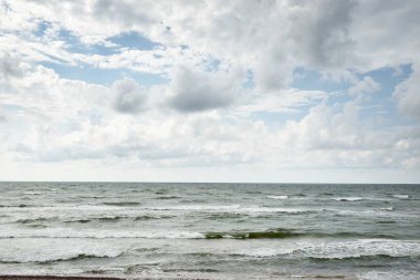 Fırtınadan sonra Baltık kıyıları (kum tepeleri, plaj). Dramatik gökyüzü, parlayan bulutlar. Resimli panoramik manzara. Doğa, çevre, ekoloji, eko-turizm, yürüyüş, keşif kavramları