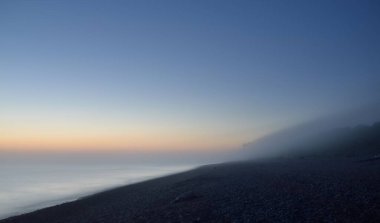 Baltık deniz kıyısının sisli manzarası nefes kesici panoramik. Parlak gökyüzü, gece yarısı güneşi, alacakaranlık. Resimli bir manzara var. Rüya gibi bir manzara. Saf doğa, çevre, ekoloji, turizm