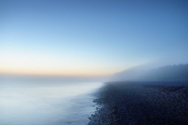 Baltık deniz kıyısının sisli manzarası nefes kesici panoramik. Parlak gökyüzü, gece yarısı güneşi, alacakaranlık. Resimli bir manzara var. Rüya gibi bir manzara. Saf doğa, çevre, ekoloji, turizm