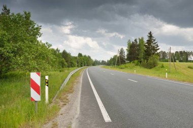 Bir yaz günü tarla ve orman boyunca (yeni asfalt yol) boş bir otoyoldur. Yağmurdan önce dramatik fırtına bulutları. Turizm, yol gezisi, özgürlük, tatiller, lojistik, uzak yerler kavramları