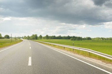 Bir yaz günü tarla ve orman boyunca (yeni asfalt yol) boş bir otoyoldur. Yağmurdan önce dramatik fırtına bulutları. Turizm, yol gezisi, özgürlük, tatiller, lojistik, uzak yerler kavramları