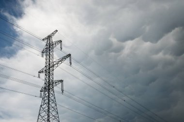 Dramatik gökyüzüne karşı elektrik hattı, yakın plan. Şehir manzarası kavramı. Enerji, enerji üretimi, özel ekipman, endüstri, çevresel hasar, ekoloji, altyapı, ormanların tahrip