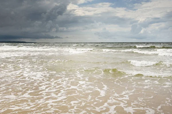 Fırtına sırasında açık bir Baltık denizi. Dramatik gökyüzü, karanlık, parlak bulutlar. Dalgalar, su sıçramaları. Idyllic deniz manzarası. Kış, iklim değişikliği, doğa, kararsız hava, tehlike