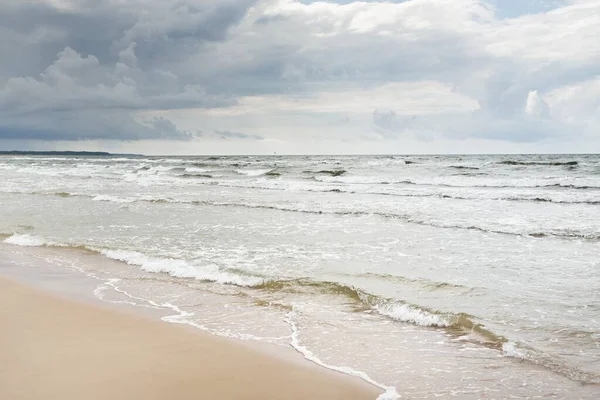 Fırtınadan sonra Baltık kıyıları (kum tepeleri, plaj). Dramatik gökyüzü, parlayan bulutlar. Resimli panoramik manzara. Doğa, çevre, ekoloji, eko-turizm, yürüyüş, keşif kavramları